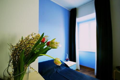 a vase with flowers sitting on a bed in a room at Hotel La Bussola in Muggia