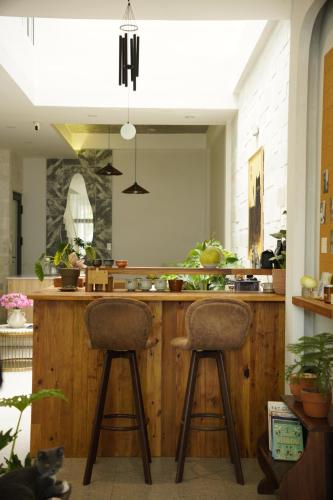 une cuisine avec deux tabourets de bar à un comptoir dans l'établissement Kim Homestay in Hue, à Thôn Lại Thê