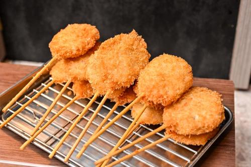 a pile of fried food on a rack with chopsticks at GRIDS PREMIUM HOTEL OSAKA NAMBA in Osaka