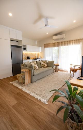 a living room with a couch and a table at Aloha Byron Bay in Byron Bay