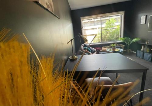 a living room with a table and a person laying on a couch at Tropical Ocean Vibe Fully Aircon House in Strathpine
