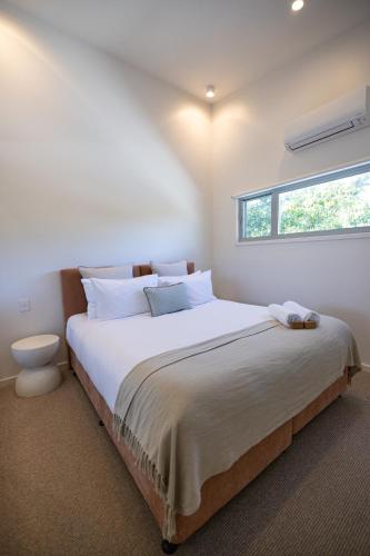 a bedroom with a large bed with a window at Aloha Byron Bay in Byron Bay
