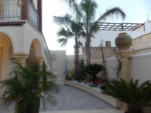 a courtyard with palm trees in a building at RIAD Comfort Rooms in San Vito lo Capo