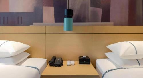 a room with two beds and a phone on a table at City Comfort Inn Liuzhou Wuling Liutai Road in Liuzhou