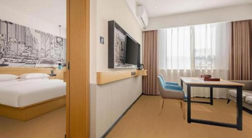 a hotel room with a bed and a table and a desk at City Comfort Inn Liuzhou Wuling Liutai Road in Liuzhou