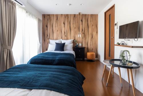 a bedroom with a bed and a table and a tv at Villa Penthouse Tenma in Osaka