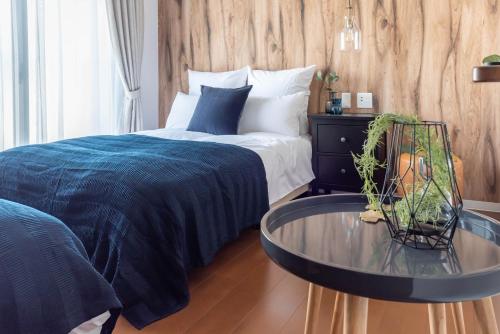 a bedroom with a bed and a glass table at Villa Penthouse Tenma in Osaka