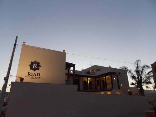 a building with a sign on the side of it at RIAD Comfort Rooms in San Vito lo Capo