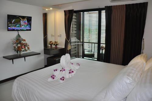 a bedroom with a white bed with flowers on it at The Gallery At Koh Chang in Ko Chang