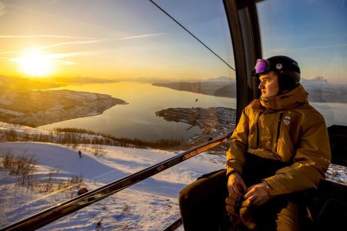 a man sitting in a ski lift with a ski pole at Narvik city apartment in Narvik