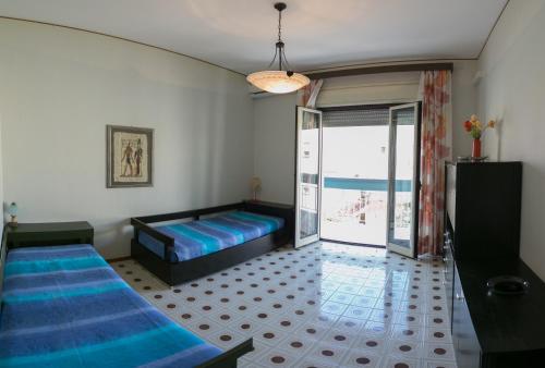 a bedroom with two beds and a balcony at Archimede Lounge in Cefalù