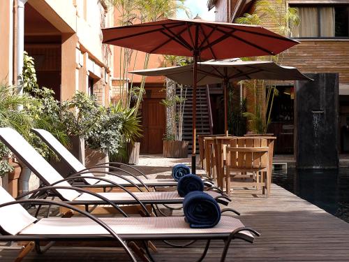 a group of chairs and umbrellas next to a pool at Hotel Sakamanga in Antananarivo