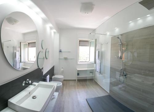 a white bathroom with a sink and a mirror at Archimede Lounge in Cefalù