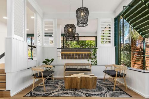 a restaurant with two tables and two chairs and windows at The Leea Resort Darwin in Darwin
