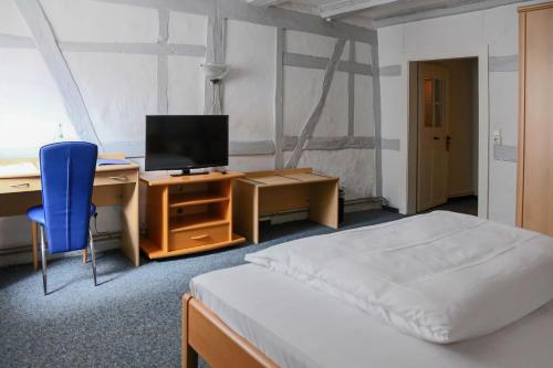 ヴァルドルフにあるHotel Haus Landgrafのベッドとパソコン付きの机がある寝室