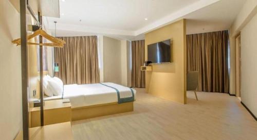 a hotel room with a bed and a television at City Comfort Inn Liuzhou Liucheng in Liuzhou