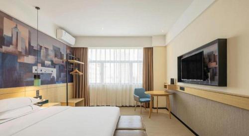 a hotel room with a bed and a television at City Comfort Inn Changsha South Railyway Station West Square in Changsha