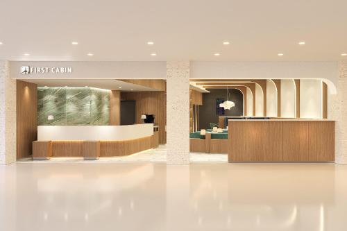a lobby of a hotel with a reception desk at First Cabin Naha Airport in Naha