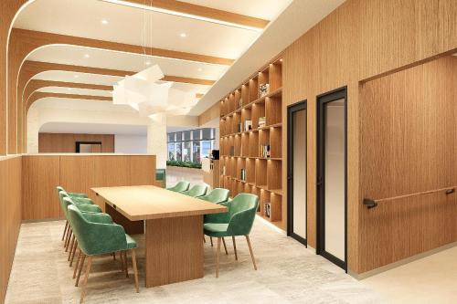 a conference room with a table and green chairs at First Cabin Naha Airport in Naha