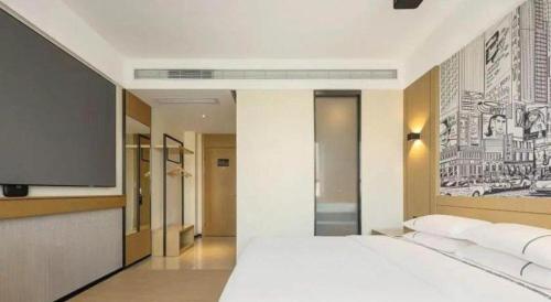 a bedroom with a white bed and a tv at City Comfort Inn Lijiang Ancient Town in Lijiang