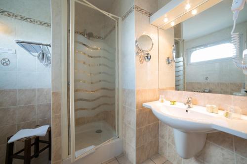 a bathroom with a sink and a shower at Logis Auberge de la Rose in Doué-la-Fontaine