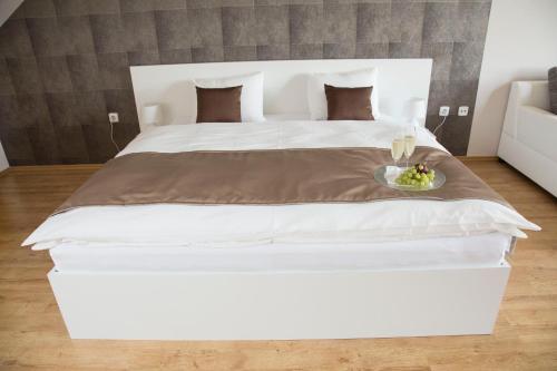 a large white bed with a plate of food on it at Villa Grande - Apartmány in Olomouc