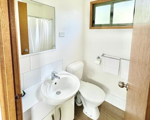a white bathroom with a toilet and a sink at BIG4 Rutherglen Holiday Park in Rutherglen