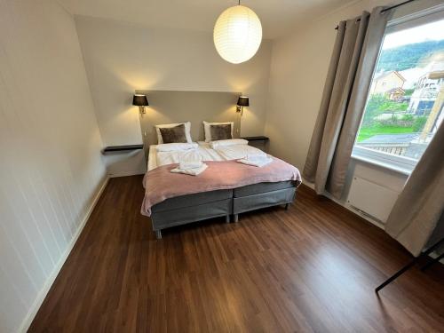 a bedroom with two beds and a large window at Central trainstation apartment in Narvik