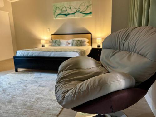 a living room with a chair and a bed at King Solomon Hotel in Honiara
