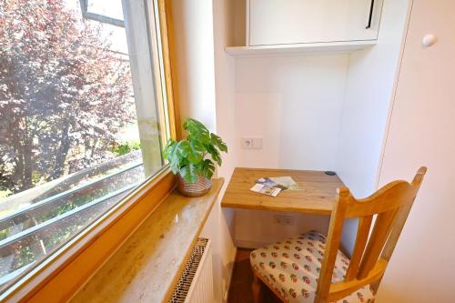 a table and a chair in a room with a window at ChiemseeGlück in Chieming