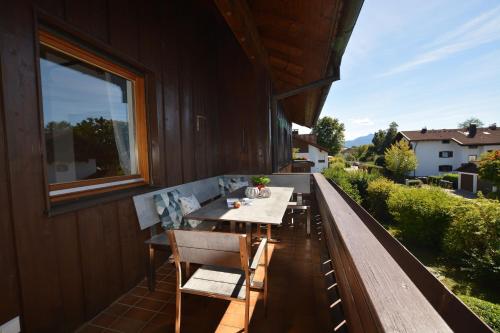 a table and chairs on the balcony of a house at ChiemseeGlück in Chieming
