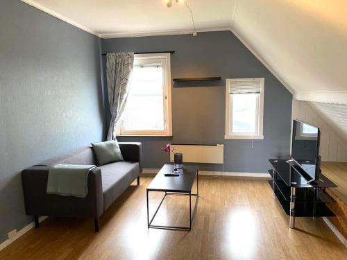 a living room with a couch and a television at Railway central loft apartment in Narvik