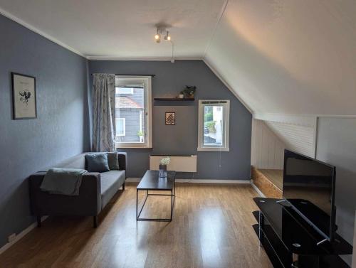a living room with a couch and a table at Railway central loft apartment in Narvik