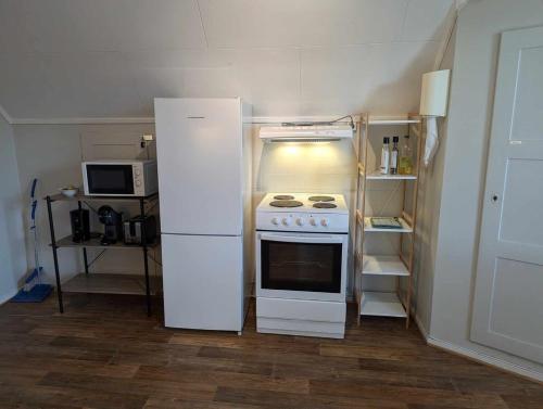 a small kitchen with a refrigerator and a stove at Railway central loft apartment in Narvik