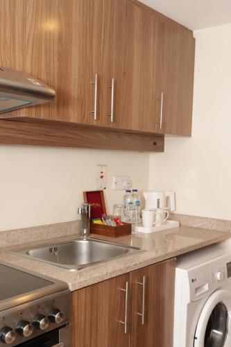 a kitchen counter with a sink and a dishwasher at Danat Al Ain Resort in Al Ain