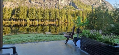 LangeidにあるCabin With Dock By Otra In Setesdalの山のある湖の横に座るベンチ
