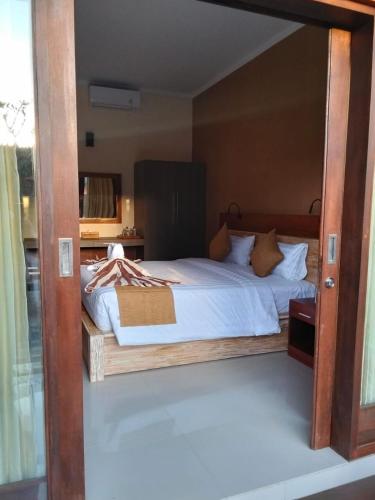 a bedroom with a large bed with a wooden frame at C'man Guest House in Mantaak