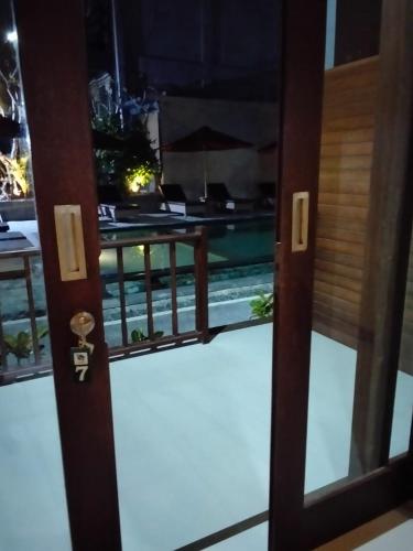 a door to a balcony with a view of a pool at C'man Guest House in Mantaak