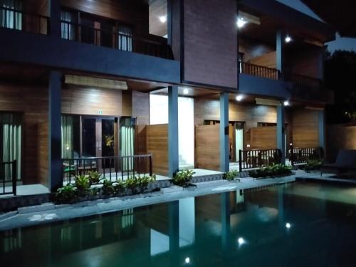 a house with a swimming pool at night at C'man Guest House in Mantaak