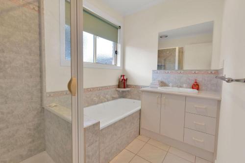 a bathroom with a tub and a sink and a shower at Villa Victoria in Paynesville