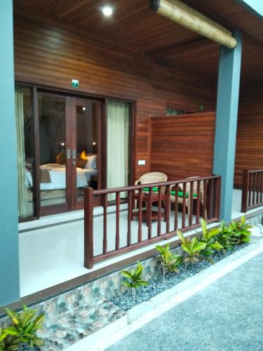 a house with a balcony with a bed at C'man Guest House in Mantaak