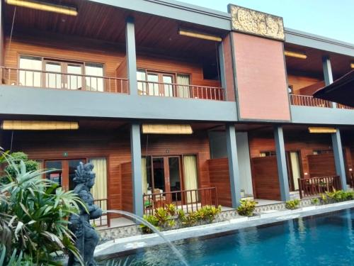 a building with a pool in front of it at C'man Guest House in Mantaak