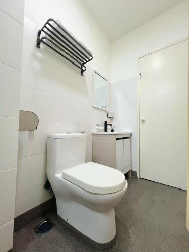 a white bathroom with a toilet and a mirror at 涵舍homestay in Sibu