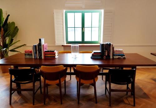 a dining room table with chairs and books on it at Hotel Brown Beach House & Spa in Trogir