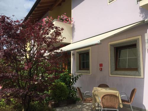 una mesa y sillas frente a una casa en Da Rita Hotel, en Condino