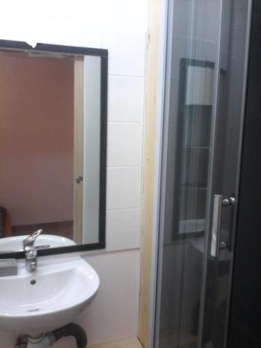 une salle de bain avec un lavabo et un miroir dans l'établissement Studio des Grenadiers, à Balaruc-les-Bains