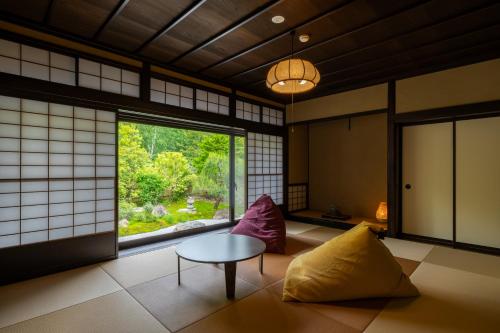 a room with a table and chairs and a window at 旅庵 川喜 in Omachi