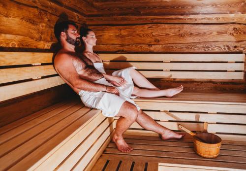 a man and woman sitting in a sauna at Hotel FIS in Štrbské Pleso