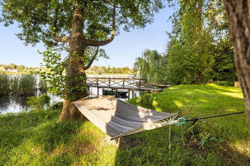 an umbrella sitting on the grass next to a tree at Cozy Wooden House By The Lake in Falkensee