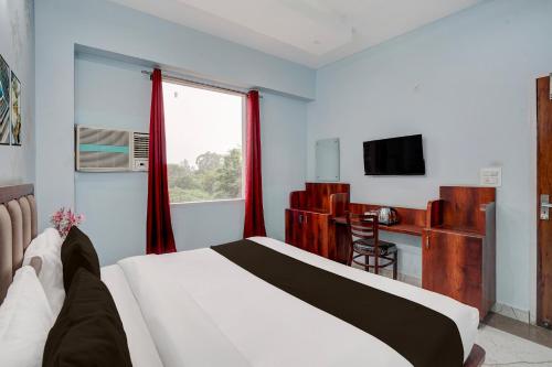 a bedroom with a bed and a desk and a television at Super Hotel O Sector 52 Chandigarh Formerly Hari Residency in Chandīgarh